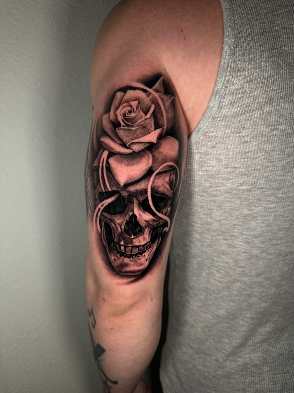 Skull and rose upper arm tattoo