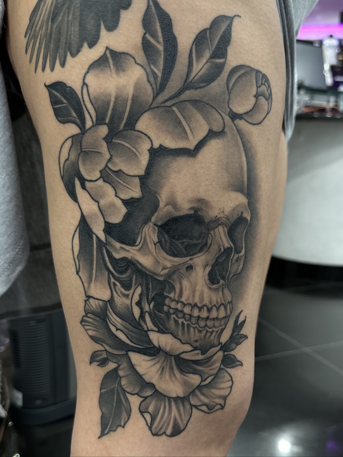 Healed skull with florals thigh tattoo