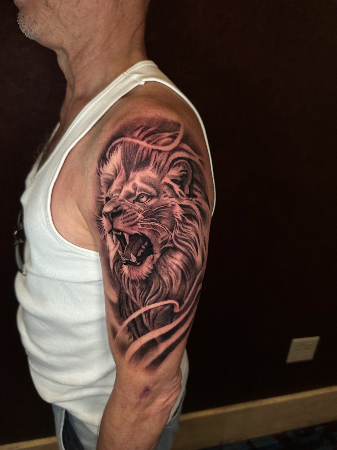 Roaring lion upper arm tattoo