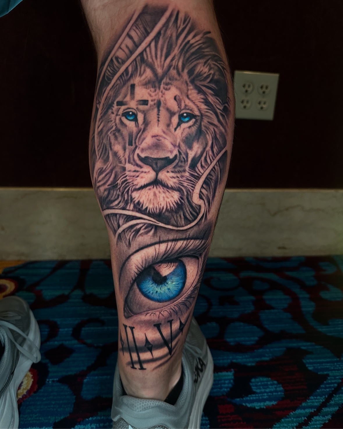 Lion and blue eye calf tattoo